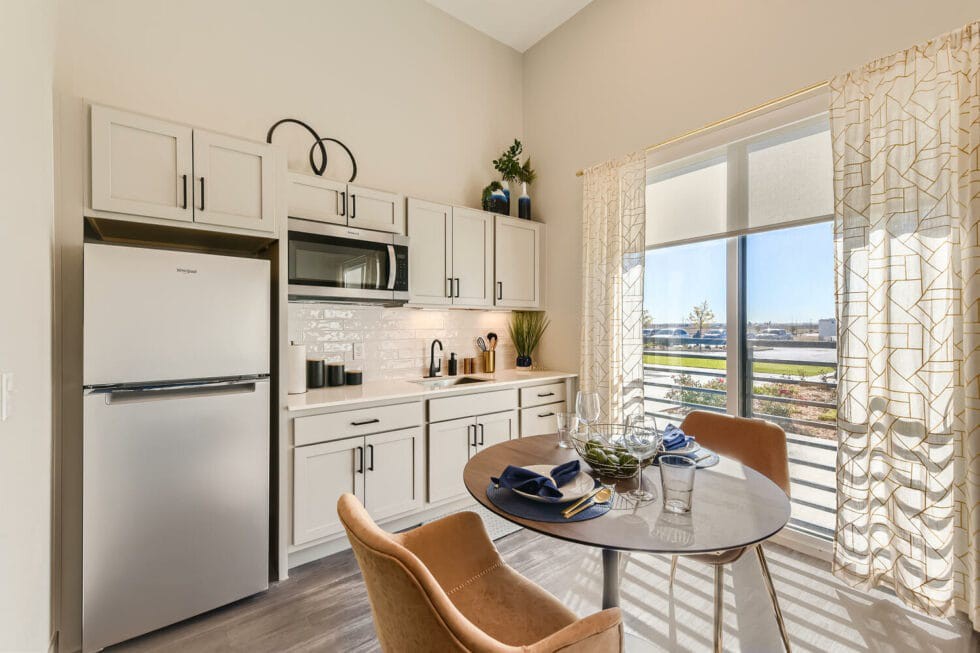 A modern kitchen and dining area with ample natural light and a compact, stylish design.