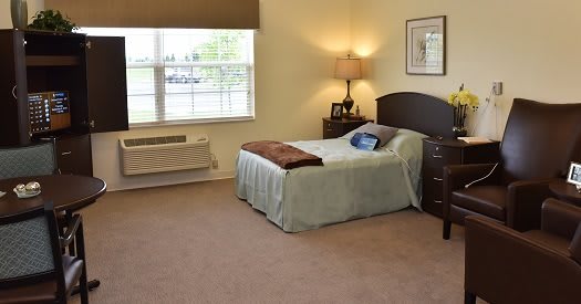 A cozy bedroom with a single bed, nightstand, and window providing natural light.
