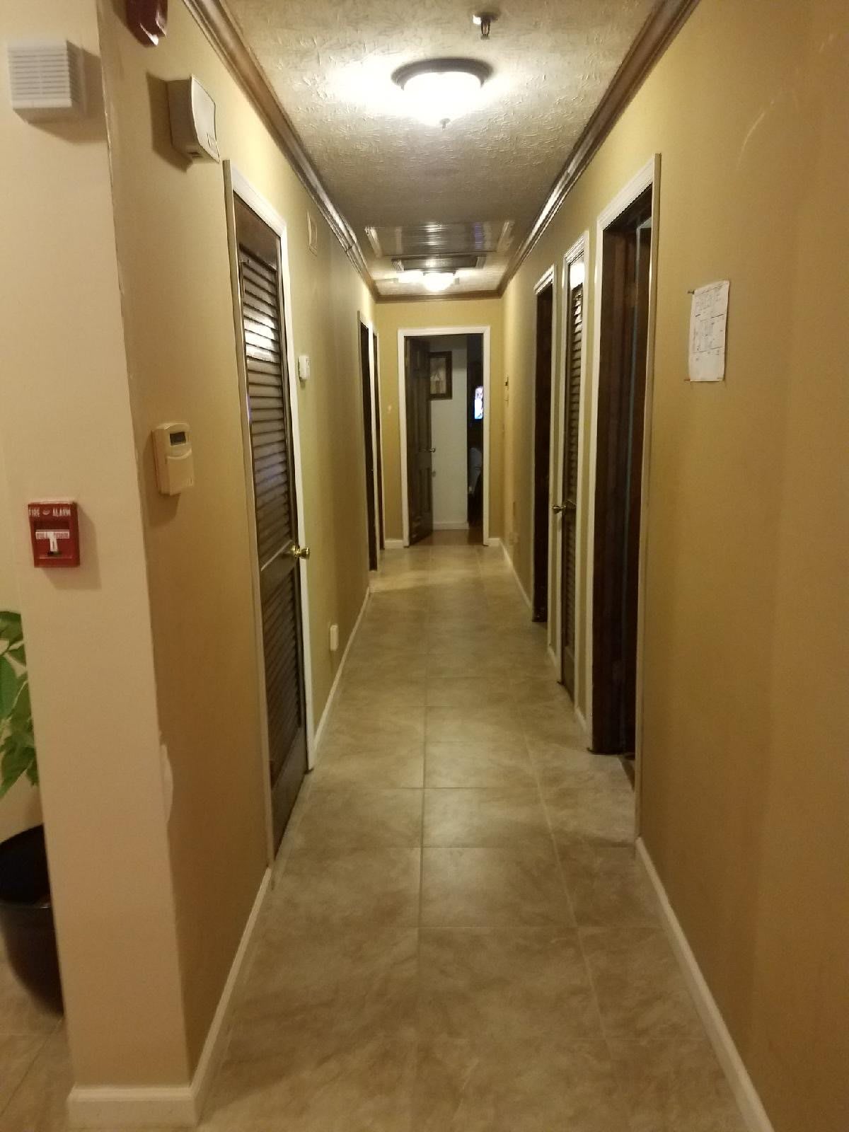 A well-lit indoor hallway with multiple doors on either side.