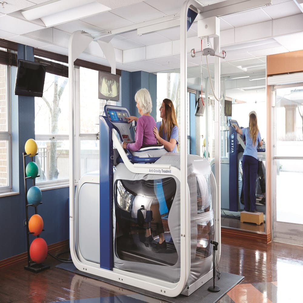 A person using advanced exercise equipment in a rehabilitation setting.