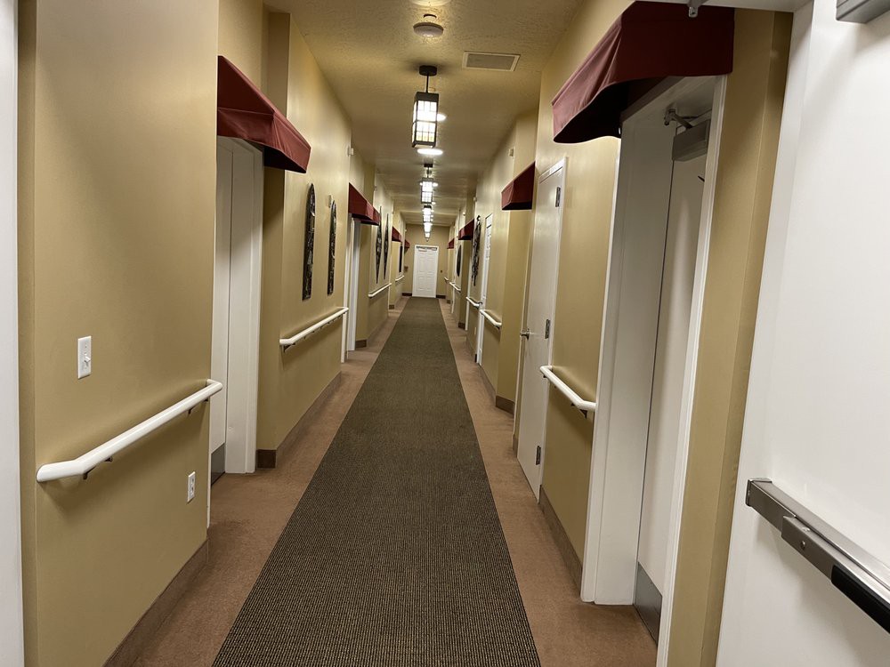 Long hallway with doors and ceiling lights.