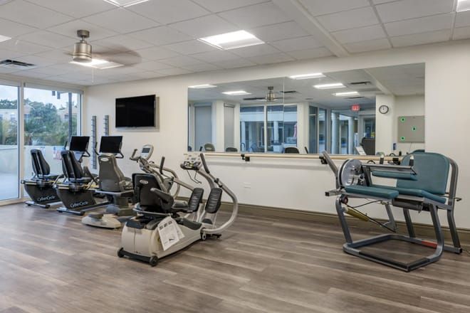 A modern gym with various exercise machines and cardio equipment.