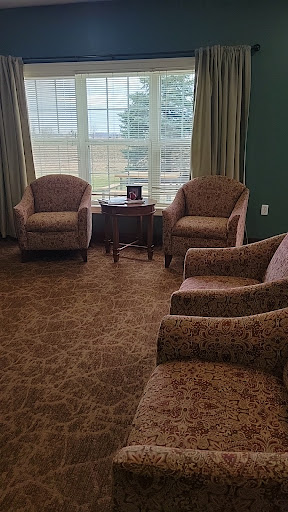 A cozy seating area featuring patterned chairs and a side table by a large window.