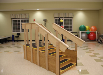 A wooden stairway designed for physical therapy, featuring multiple steps for rehabilitation exercises.