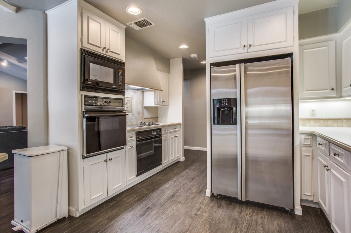 A modern kitchen with stainless steel appliances and white cabinetry.