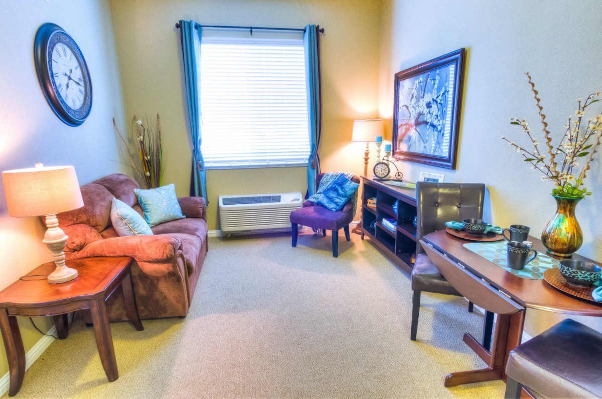 A cozy living room with modern furniture and a large window letting in natural light.