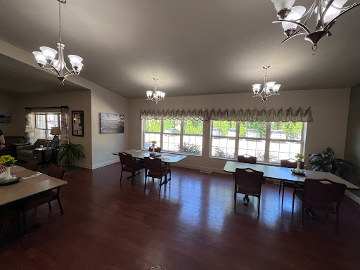 A spacious and well-lit dining area featuring tables and chairs, complemented by natural light from the large windows.