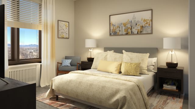 A cozy bedroom with neutral tones, featuring a neatly made bed, decorative pillows, a bedside lamp, and framed artwork on the wall.