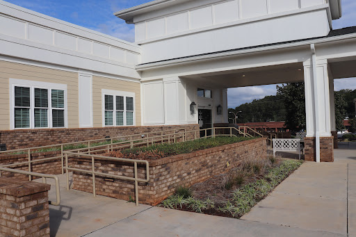 A modern building entrance with a landscaped pathway and accessibility features.