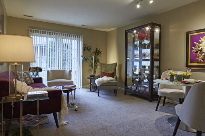 A modern living room with comfortable seating and a glass display cabinet.
