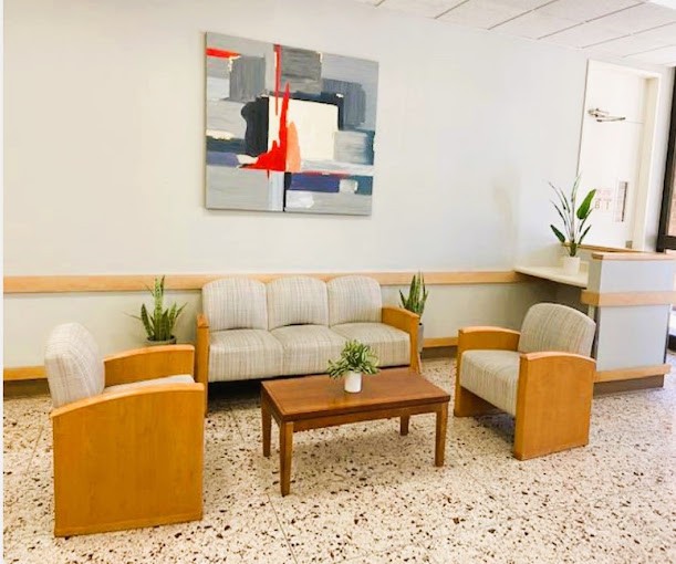 A modern lobby with comfortable seating, artwork on the wall, and decorative plants.