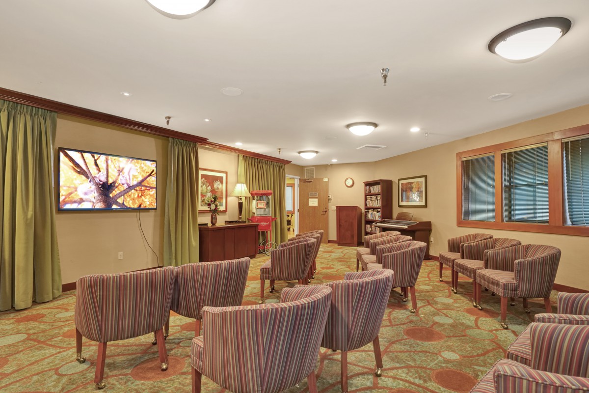 A well-arranged meeting room with rows of chairs, elegant decor, and warm lighting.