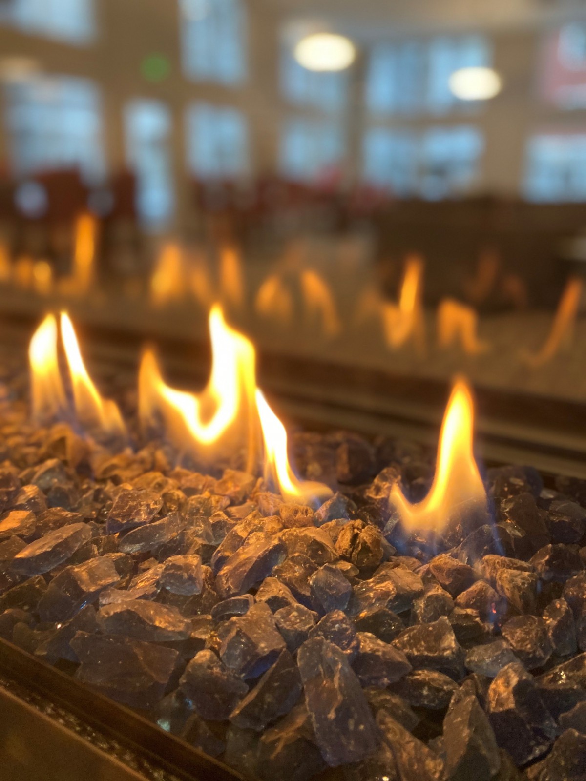 A cozy indoor gas fireplace with glowing flames.