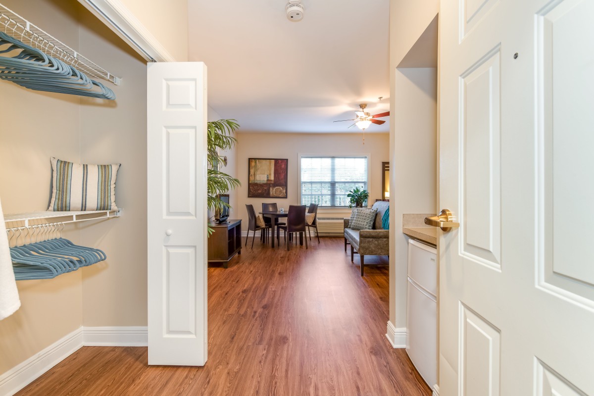A modern living and dining area with hardwood floors and bright lighting.