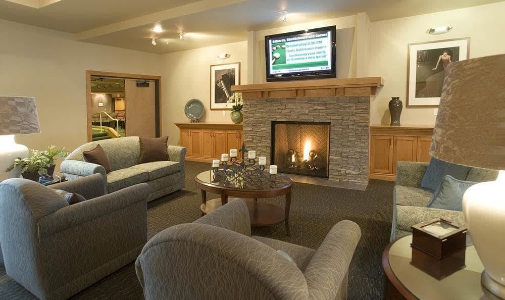 A cozy living room with comfortable seating, a fireplace, and a television.