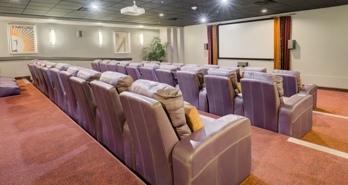 A luxurious home theater with plush seating and a large screen.