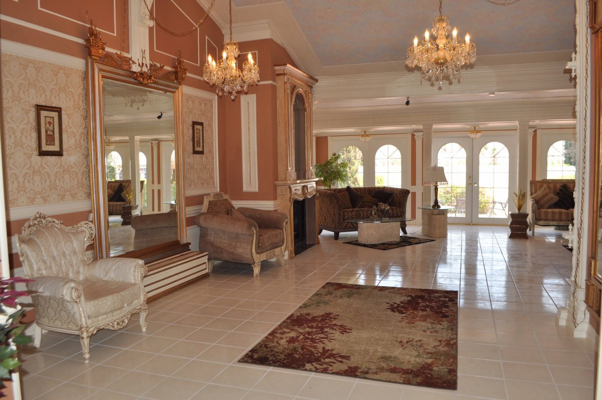 An elegant lobby with chandeliers, plush furniture, and a large mirror.