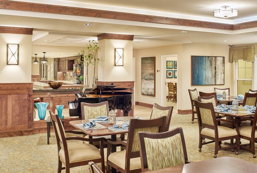 An elegantly designed dining area with neatly arranged tables and chairs, complemented by artwork on the walls.