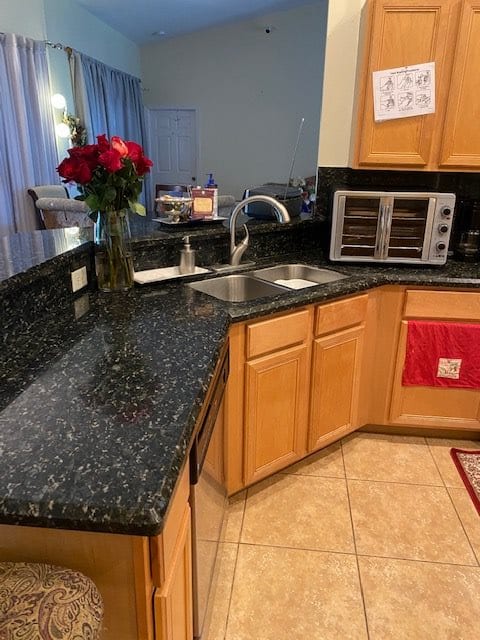 A kitchen with granite countertops, a sink, and a small oven.