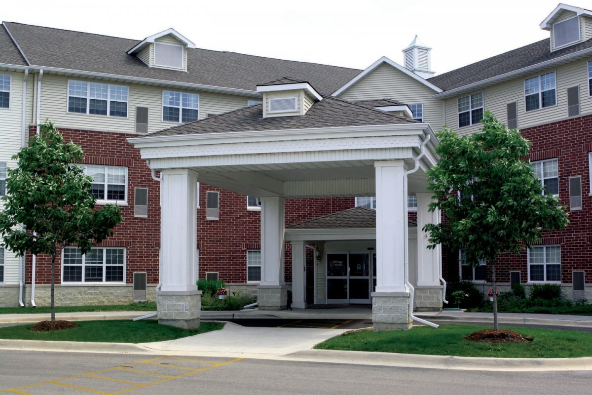 A residential building with a covered entrance and brick facade.