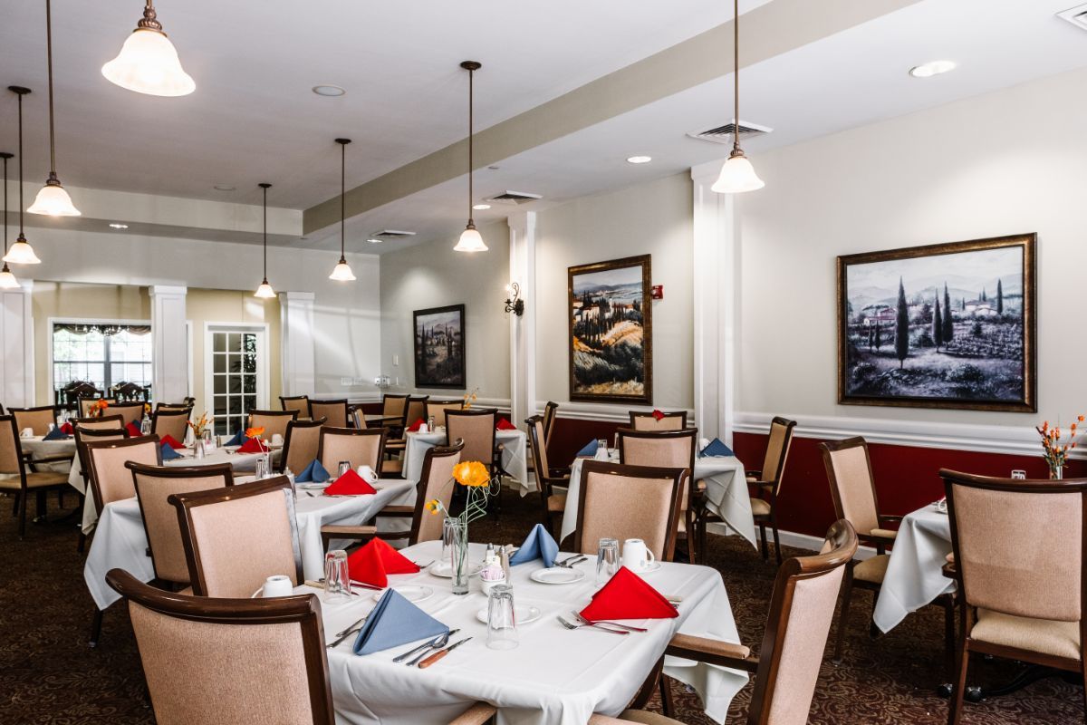 A well-arranged dining area with tables set with colorful napkins, ready for guests.