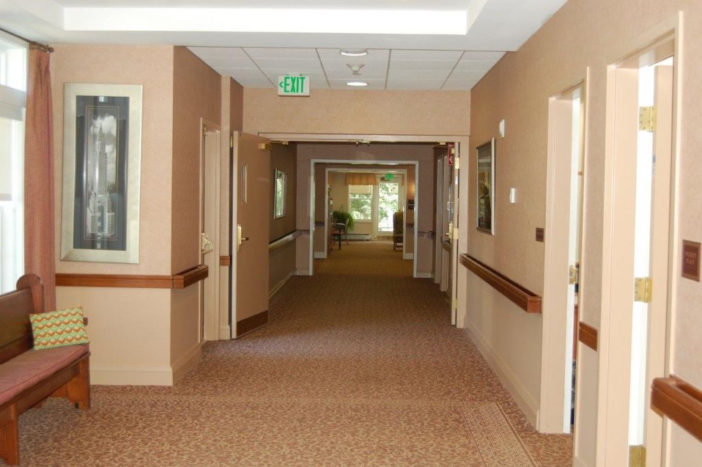 An empty hallway with multiple doorways and beige walls inside a building.