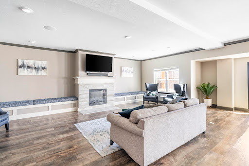 A stylish and modern living room featuring a cozy seating area, a fireplace, and ample natural light.