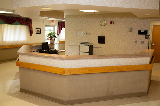 A clean and minimalist reception area with a desk and plants, offering a welcoming atmosphere.