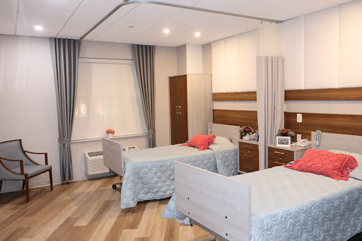 A well-designed hospital patient room featuring two beds, modern furnishings, and a bright atmosphere.