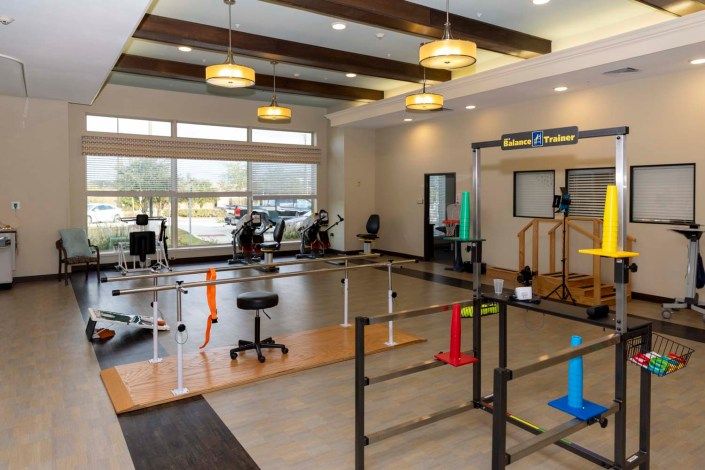 A spacious rehabilitation and physical therapy center equipped with various exercise machines and therapy apparatus.