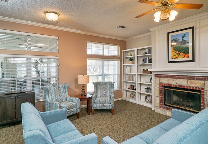 A cozy living room with comfortable seating, a fireplace, and a bookshelf.