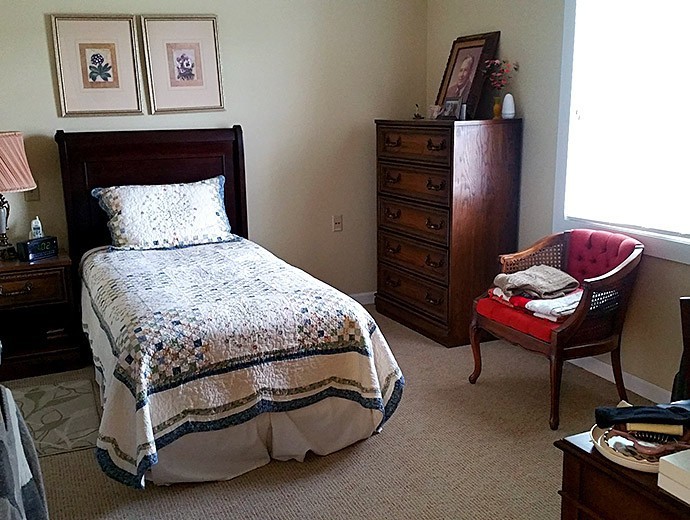 A cozy bedroom with a single bed and classic wooden furniture.