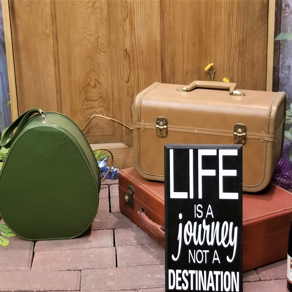 A collection of vintage suitcases with an inspirational travel quote.