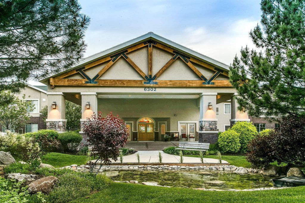 A scenic view of a building entrance surrounded by a well-maintained garden.