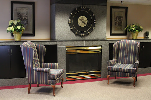 A cozy living room setup featuring striped armchairs and a decorative fireplace.