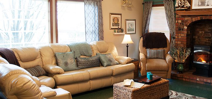 A cozy living room with a comfortable sofa adorned with cushions, a warm lamp, and elegant decor.