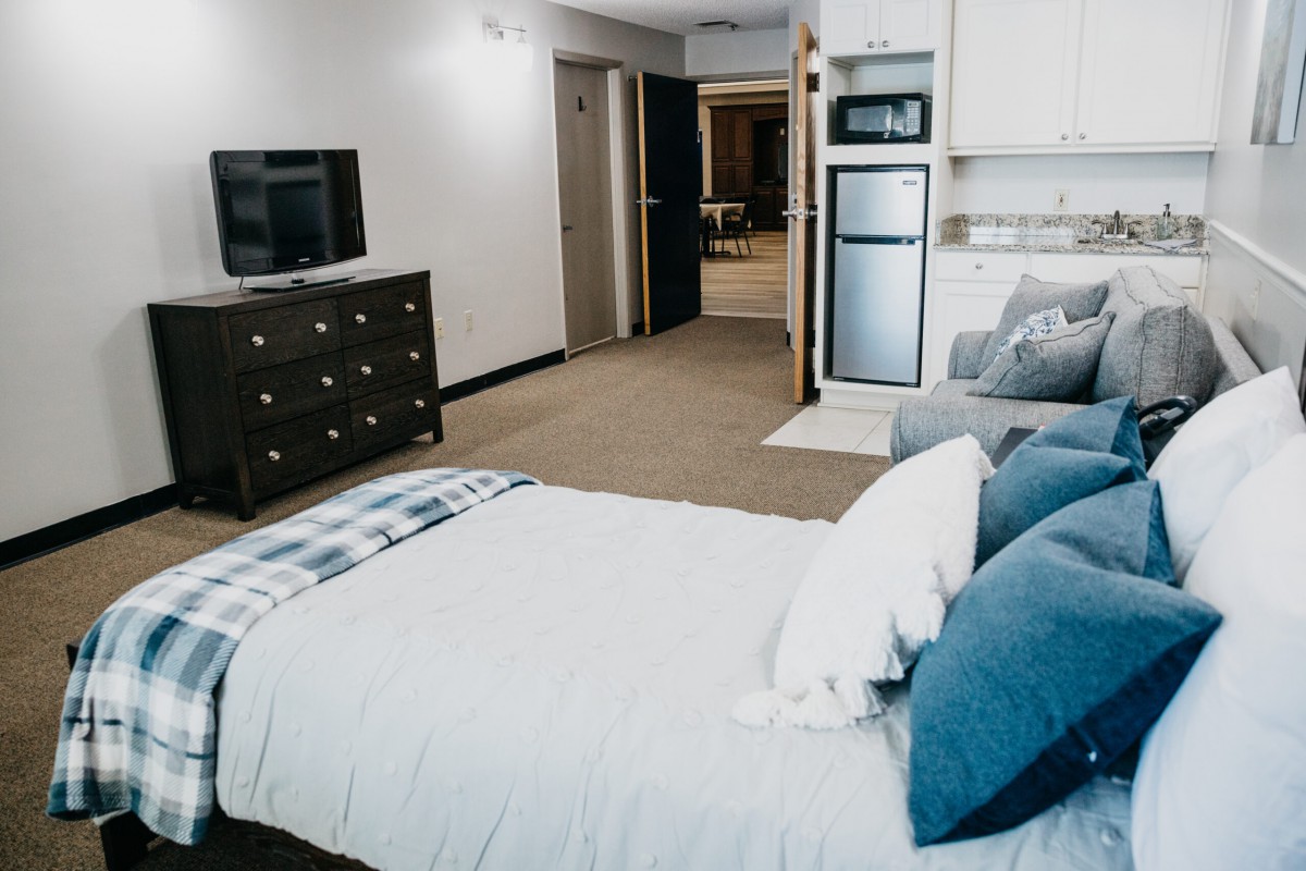 A cozy and modern bedroom with a bed, dresser, and television.
