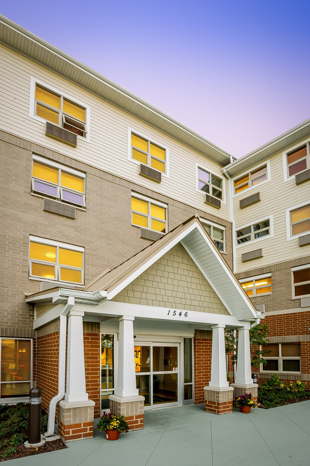 A residential apartment building with multiple windows and a prominent entrance.