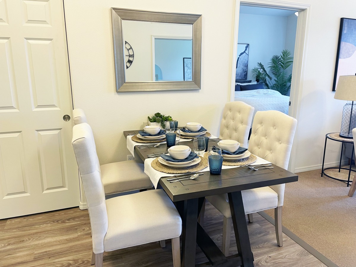 A modern dining room with a stylish table setting and upholstered chairs.