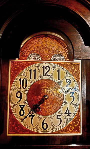An ornate antique grandfather clock displaying the time.