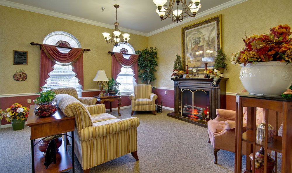 A cozy, traditionally styled living room featuring a fireplace, elegant furniture, and decorative accents.