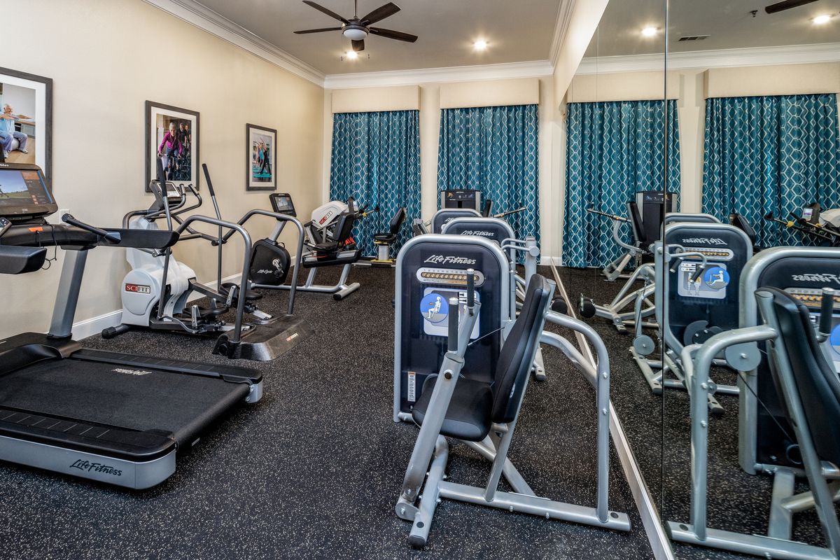 A well-equipped gym with various fitness machines, including treadmills and exercise bikes.