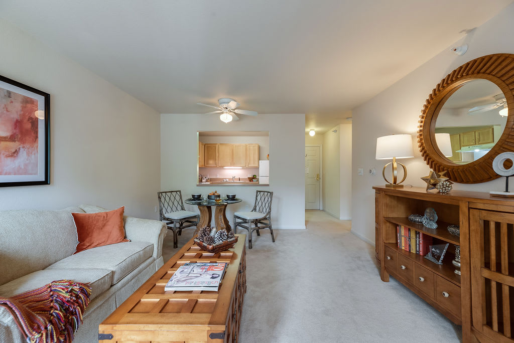 Cozy living room with a comfortable sofa, coffee table, and a small dining area in the background.