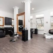 A modern and bright hair salon interior with mirrors, chairs, and styling stations.
