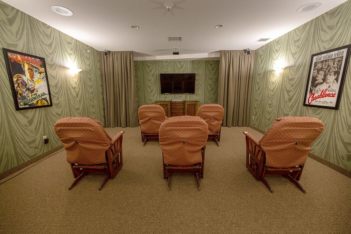 A cozy home theater with comfortable seating and a large TV screen.