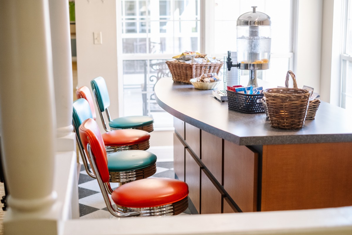 A retro-style diner with colorful bar stools and a classic countertop.