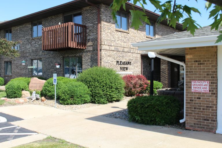 An exterior view of an apartment building with well-maintained landscaping.