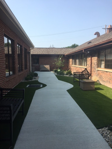 A serene courtyard with a winding pathway surrounded by greenery.