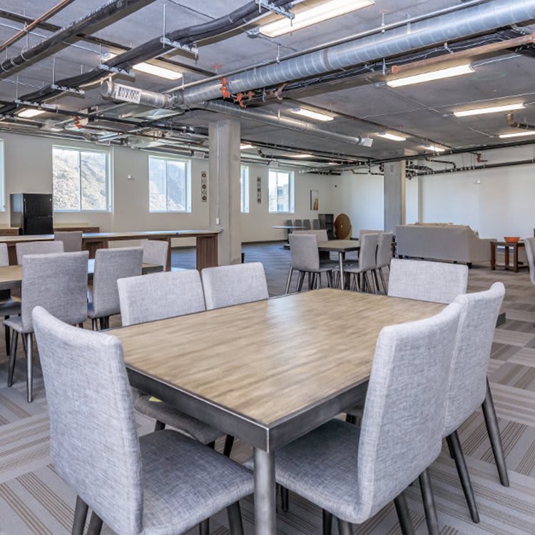 A modern office meeting area with tables and chairs.