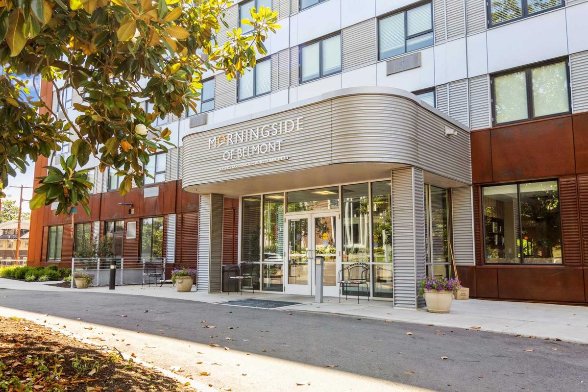 Modern hotel entrance with glass doors and signage.